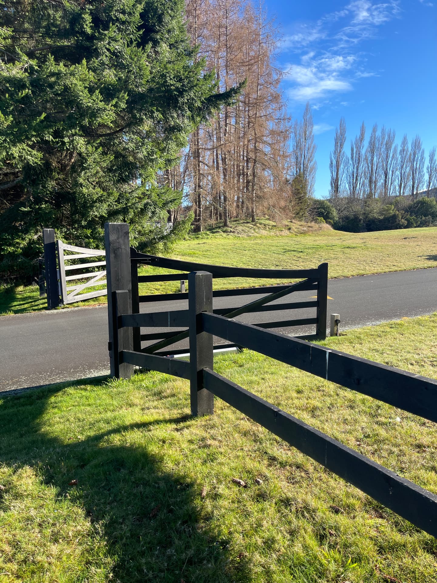 The black timber gate and fence at the entrance to The Fairways